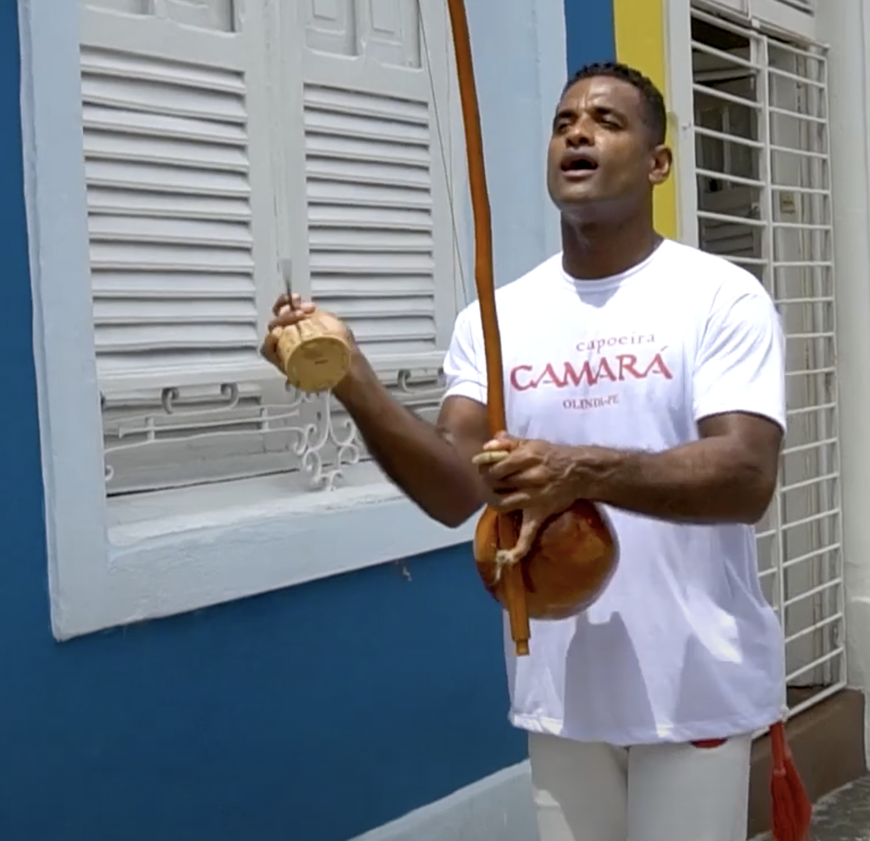 Mestre Bola playing a berimbau and singing